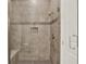 Modern walk-in shower with neutral tiling, built-in seat, and recessed shelf, enclosed by glass doors at 13628 Abberwick Dr, Orlando, FL 32832