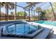 Inviting hot tub and screened-in pool area, perfect for relaxation with tropical backyard views at 1404 Barcelona Ct, Winter Springs, FL 32708
