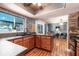Open kitchen featuring stone accent wall, dark countertops, wood cabinets and view to living room at 1404 Barcelona Ct, Winter Springs, FL 32708