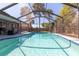 Sparkling pool enclosed in screened lanai with palms and outdoor kitchen; perfect for entertaining at 1404 Barcelona Ct, Winter Springs, FL 32708