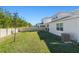 Expansive backyard with lush green grass, privacy fence, and exterior views of the home's architecture at 14399 Wabasso Loop, Winter Garden, FL 34787