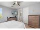 Bedroom featuring a ceiling fan, TV, wooden dresser and an ensuite bathroom at 14399 Wabasso Loop, Winter Garden, FL 34787