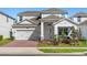 Charming two-story home with a brick driveway, manicured lawn and gray exterior at 14399 Wabasso Loop, Winter Garden, FL 34787