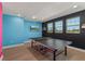 Spacious game room with a ping pong table, vibrant wall colors, and natural light from multiple windows at 14399 Wabasso Loop, Winter Garden, FL 34787
