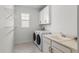 Functional laundry room equipped with a sink, washer, dryer, and storage cabinets at 14399 Wabasso Loop, Winter Garden, FL 34787