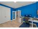 Bright blue office space with a hardwood floor and computer setup at 14399 Wabasso Loop, Winter Garden, FL 34787