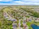 Wide aerial view showcasing the neighborhood, houses, landscaping, and a lake at 14410 Lake Underhill Rd, Orlando, FL 32828