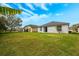 The backyard has a large grassy area behind the home with a view of neighboring houses at 14410 Lake Underhill Rd, Orlando, FL 32828