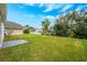 Spacious backyard with lush green grass and some surrounding trees and bushes at 14410 Lake Underhill Rd, Orlando, FL 32828