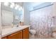 Well-lit bathroom features a vanity with sink, floral shower curtain, and toilet at 14410 Lake Underhill Rd, Orlando, FL 32828