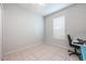 Clean bedroom with tile flooring, neutral walls, a window, and desk with office chair at 14410 Lake Underhill Rd, Orlando, FL 32828