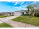 Charming single-story home featuring a two-car garage, manicured lawn, and landscaped front yard at 14410 Lake Underhill Rd, Orlando, FL 32828