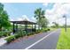Charming outdoor gazebo with benches on a paved path next to a pond at 14410 Lake Underhill Rd, Orlando, FL 32828