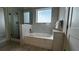Clean bathroom with a soaking tub, glass-enclosed shower, and sleek tile work at 14501 Grove Resort Ave # 3601, Winter Garden, FL 34787