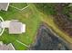 Aerial view of a home with a large, grassy yard, adjacent to a scenic pond and conservation area at 15216 Langsdale Ct, Mascotte, FL 34753