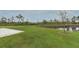 Spacious backyard with lush green grass and a tranquil pond at 15216 Langsdale Ct, Mascotte, FL 34753