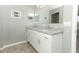 Bathroom boasts double sinks with granite countertops and wood-look tile floors at 15216 Langsdale Ct, Mascotte, FL 34753