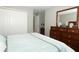 Carpeted bedroom showcases a wooden dresser, a white closet and a queen sized bed at 15216 Langsdale Ct, Mascotte, FL 34753