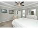 A well-lit bedroom with a comfortable chair, dresser and ceiling fan above the bed at 15216 Langsdale Ct, Mascotte, FL 34753