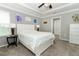 Comfortable bedroom features a tray ceiling, ceiling fan and a window letting in natural light at 15216 Langsdale Ct, Mascotte, FL 34753