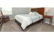 Carpeted bedroom has a wood bed frame, side table and a cozy rocking chair at 15216 Langsdale Ct, Mascotte, FL 34753