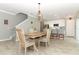 Open-concept dining area featuring modern light fixture and open flow to the kitchen and staircase at 15216 Langsdale Ct, Mascotte, FL 34753