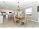 Spacious dining area adjacent to the kitchen, featuring stylish lighting and wood-look tile floors at 15216 Langsdale Ct, Mascotte, FL 34753