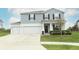 Lovely two-story home featuring a three-car garage, manicured lawn and welcoming front entry at 15216 Langsdale Ct, Mascotte, FL 34753