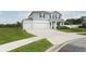 Exterior view of a two-story home featuring a three-car garage and a well-maintained lawn at 15216 Langsdale Ct, Mascotte, FL 34753