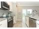 Bright and functional kitchen featuring stainless appliances, ample counter space, and white cabinets at 15216 Langsdale Ct, Mascotte, FL 34753