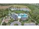 Aerial view of the community clubhouse, playground, and pool with a pond, offering recreational opportunities at 17398 Saw Palmetto Ave, Clermont, FL 34714