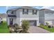 Charming two-story home with a gray garage and brick-paved driveway at 17398 Saw Palmetto Ave, Clermont, FL 34714