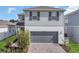 Charming two-story home with a gray garage and brick-paved driveway at 17398 Saw Palmetto Ave, Clermont, FL 34714