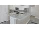 Bright kitchen features a gray backsplash and island, stainless steel appliances, and ample white cabinetry at 17398 Saw Palmetto Ave, Clermont, FL 34714