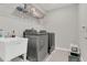 Functional laundry room with modern washer, dryer, and utility sink at 17398 Saw Palmetto Ave, Clermont, FL 34714