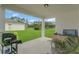 Covered patio featuring a grill and ample space, overlooking a lush green lawn at 17398 Saw Palmetto Ave, Clermont, FL 34714