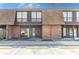 Exterior view of a two-story townhome featuring brick accents, a textured roof and parking spots at 1836 N Crystal Lake Dr # 104, Lakeland, FL 33801