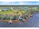 Stunning aerial view of waterfront property with docks, lush trees, and neighborhood in the distance at 18951 Lake Pickett Rd, Orlando, FL 32820