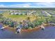 Scenic aerial view of waterfront property featuring private docks, lush vegetation, and neighborhood in the distance at 18951 Lake Pickett Rd, Orlando, FL 32820