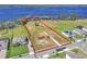 Aerial view of a large, undeveloped lot with water access, bordered by mature trees and adjacent to a residential area at 18951 Lake Pickett Rd, Orlando, FL 32820