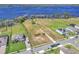 Aerial view of a large, undeveloped lot with water access, bordered by mature trees and adjacent to a residential area at 18951 Lake Pickett Rd, Orlando, FL 32820