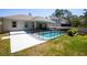Fenced backyard view with an in-ground pool and covered patio with seating area at 2050 1St Ave, Deland, FL 32724