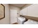 Laundry room features a washing machine, dryer, white cabinets, and door at 2050 1St Ave, Deland, FL 32724