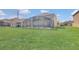 Sprawling backyard showcasing a screened pool enclosure and lush green lawn perfect for outdoor enjoyment at 2136 Crofton Ave, Davenport, FL 33837