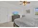 Bedroom boasts a ceiling fan, window view and rustic wood dresser at 2136 Crofton Ave, Davenport, FL 33837