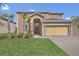 Two-story home featuring a two-car garage, well-maintained lawn, and front yard landscaping at 2136 Crofton Ave, Davenport, FL 33837