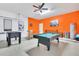 Spacious garage game room features a pool table, foosball table, and bright orange walls at 2136 Crofton Ave, Davenport, FL 33837