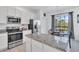 Modern kitchen featuring stainless steel appliances, granite counters, and a view to breakfast nook at 2136 Crofton Ave, Davenport, FL 33837