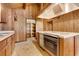 Kitchen with wood cabinets, vintage oven, and shelving in a home featuring wood paneling and high ceilings at 220 Wekiva Park Drive, Sanford, FL 32771