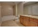 Well-lit bathroom with tiled floor, granite countertop vanity, and bathtub with shower at 225 W Seminole Blvd # 213, Sanford, FL 32771